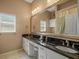 Primary bathroom featuring double sinks, granite countertops, and a large framed mirror at 9216 Tarleton Cir, Weeki Wachee, FL 34613