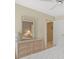 Bright main bedroom with a dresser and mirror, ceiling fan, and access to the ensuite bathroom at 9216 Tarleton Cir, Weeki Wachee, FL 34613