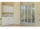Outdoor kitchen with white cabinets and a sink, next to a sliding glass door at 9216 Tarleton Cir, Weeki Wachee, FL 34613
