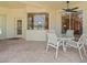 Outdoor dining area with a white table and four chairs, adjacent to the enclosed patio at 9216 Tarleton Cir, Weeki Wachee, FL 34613