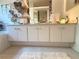 Clean bathroom with double sinks, lots of towels, under-sink cabinet storage, and decorative mirror at 9311 Haas Dr, Hudson, FL 34669