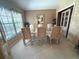 Bright dining room with carpet, large windows, six chairs, and a glass-top table at 9311 Haas Dr, Hudson, FL 34669