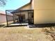 Rear exterior view of the home showing the enclosed screened in patio area and back yard at 9311 Haas Dr, Hudson, FL 34669