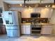 Charming kitchen features stainless steel appliances and granite countertops with mosaic tile backsplash at 9311 Haas Dr, Hudson, FL 34669