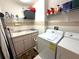 A tidy laundry room with a washing machine, dryer, utility sink, and ample storage shelving at 9311 Haas Dr, Hudson, FL 34669