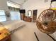 Bright bedroom with a large window, decorative hanging chair, and ensuite bathroom entrance at 9311 Haas Dr, Hudson, FL 34669