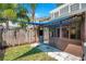 Enclosed patio with a brown frame, sliding glass doors, leading to a fenced yard with green grass at 956 Franklin Ct, Palm Harbor, FL 34683
