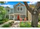 Townhome with a bright red front door and well-maintained landscaping, surrounded by mature trees at 956 Franklin Ct, Palm Harbor, FL 34683