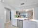 Bright kitchen featuring white cabinets, stainless steel appliances, and a view to the living area at 956 Franklin Ct, Palm Harbor, FL 34683