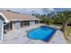 Backyard with pool, patio area, and view of house with sliding glass doors at 9930 San Diego Way, Port Richey, FL 34668