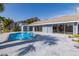 Backyard with pool, patio and view of house with enclosed porch at 9930 San Diego Way, Port Richey, FL 34668