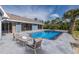 Backyard with pool, patio area, and seating with pillows and cushions at 9930 San Diego Way, Port Richey, FL 34668