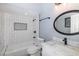 Bathroom featuring marble vanity, a round mirror, and a shower/tub combo with a white tile surround at 9930 San Diego Way, Port Richey, FL 34668