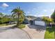 Well-maintained home featuring a spacious driveway, two-car garage, and mature landscaping at 9930 San Diego Way, Port Richey, FL 34668