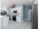 Bright kitchen with stainless steel appliances, white cabinets, tile backsplash, and a view of the backyard pool at 9930 San Diego Way, Port Richey, FL 34668