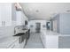 Modern kitchen with stainless appliances, white cabinets, and an island, adjacent to a dining area, creating an inviting space at 9930 San Diego Way, Port Richey, FL 34668