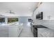 Stylish open kitchen featuring an island, stainless appliances, tile backsplash, and sliding doors to the pool area at 9930 San Diego Way, Port Richey, FL 34668