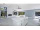 Bright living area with an island, tile floors, and sliding glass doors providing views of and access to the outdoor pool at 9930 San Diego Way, Port Richey, FL 34668