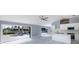 Open-concept living area with tile floors and modern kitchen featuring stainless appliances, white cabinets, and outdoor access to the pool at 9930 San Diego Way, Port Richey, FL 34668