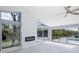 Bright living room with a modern fireplace and scenic backyard views through large windows at 9930 San Diego Way, Port Richey, FL 34668