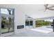 Bright living room featuring a modern fireplace and scenic backyard views through large windows at 9930 San Diego Way, Port Richey, FL 34668