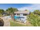 A beautiful in-ground pool is adjacent to a covered patio overlooking a tranquil waterway at 9930 San Diego Way, Port Richey, FL 34668