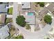 Aerial view of a home with a gray roof, driveway, screened pool, mature tree, and street access at 9942 Woodridge Ct, Port Richey, FL 34668