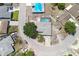Aerial view of a home with a gray roof, driveway, screened pool, mature tree, and street access at 9942 Woodridge Ct, Port Richey, FL 34668