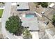 Aerial view of home featuring a screened-in pool, fenced yard, mature tree, and concrete driveway at 9942 Woodridge Ct, Port Richey, FL 34668