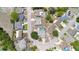 Aerial view of a home with a screened pool, fenced yard, large tree, and quiet street access at 9942 Woodridge Ct, Port Richey, FL 34668