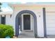 Close-up of the front door showing a well-maintained arched entryway with visible house number at 9942 Woodridge Ct, Port Richey, FL 34668