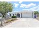 Charming single-story home featuring a well-manicured lawn, arched entryway, and a two-car garage at 9942 Woodridge Ct, Port Richey, FL 34668