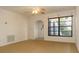 Bright living room with tan carpet, ceiling fan, and window with privacy blinds at 9942 Woodridge Ct, Port Richey, FL 34668