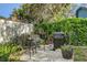 Backyard patio with grill, surrounded by green foliage and white privacy fence at 10910 Winter Oak Pl, Tampa, FL 33618