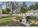 Large backyard featuring a garden with raised beds, white fencing, and an outdoor grill at 10910 Winter Oak Pl, Tampa, FL 33618