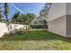 Fenced backyard, featuring a lawn and lush green trees around the property at 10910 Winter Oak Pl, Tampa, FL 33618