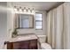 Bathroom featuring a granite vanity, decorative mirror, and tiled shower at 10910 Winter Oak Pl, Tampa, FL 33618