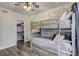 Bedroom with hardwood floors, bunk beds, wood accent wall, and a walk-in closet at 10910 Winter Oak Pl, Tampa, FL 33618