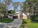 Aerial view of the property featuring the driveway, garage, and well-manicured lawn at 10910 Winter Oak Pl, Tampa, FL 33618