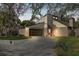 Exterior facade showcasing attached garage, red front door, and well-maintained lawn at 10910 Winter Oak Pl, Tampa, FL 33618