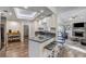 A charming kitchen featuring white cabinets, granite countertops, a breakfast bar, stainless steel appliances, and hardwood floors at 10910 Winter Oak Pl, Tampa, FL 33618