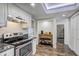 Kitchen with stainless steel appliances, wooden floors, and access to hallway at 10910 Winter Oak Pl, Tampa, FL 33618
