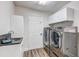 Laundry room with modern washer, dryer, and wash basin at 10910 Winter Oak Pl, Tampa, FL 33618