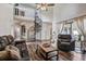 Open living room with hardwood floors, a spiral staircase, vaulted ceilings, leather furniture, and lots of natural light at 10910 Winter Oak Pl, Tampa, FL 33618