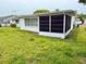 Exterior view of the home featuring an enclosed lanai in the backyard at 11224 Yewtree Ave, Port Richey, FL 34668