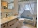 Bright bathroom featuring a tub with shower, single sink vanity, and white toilet at 11224 Yewtree Ave, Port Richey, FL 34668