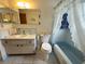 Clean bathroom featuring a vanity, toilet, bathtub with shower, and neutral-toned tile at 11224 Yewtree Ave, Port Richey, FL 34668