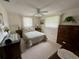 Cozy bedroom with neutral carpeting, ceiling fan, and coordinated side tables and decor at 11224 Yewtree Ave, Port Richey, FL 34668