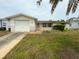 Charming single-story home featuring an attached garage, white exterior, and landscaping at 11224 Yewtree Ave, Port Richey, FL 34668