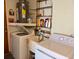 Functional laundry area with washer, dryer, sink, shelving, and hot water tank at 11224 Yewtree Ave, Port Richey, FL 34668